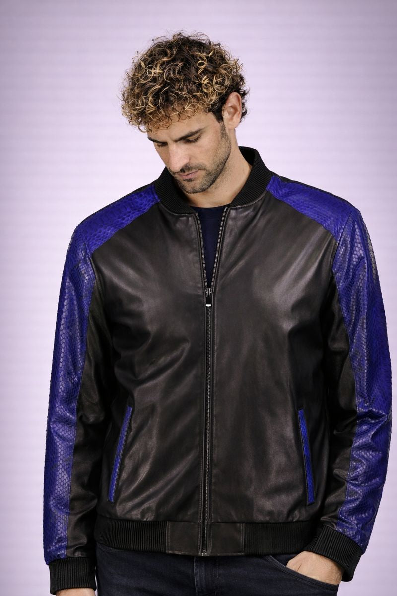 Man wearing a black and blue leather jacket against a light purple background