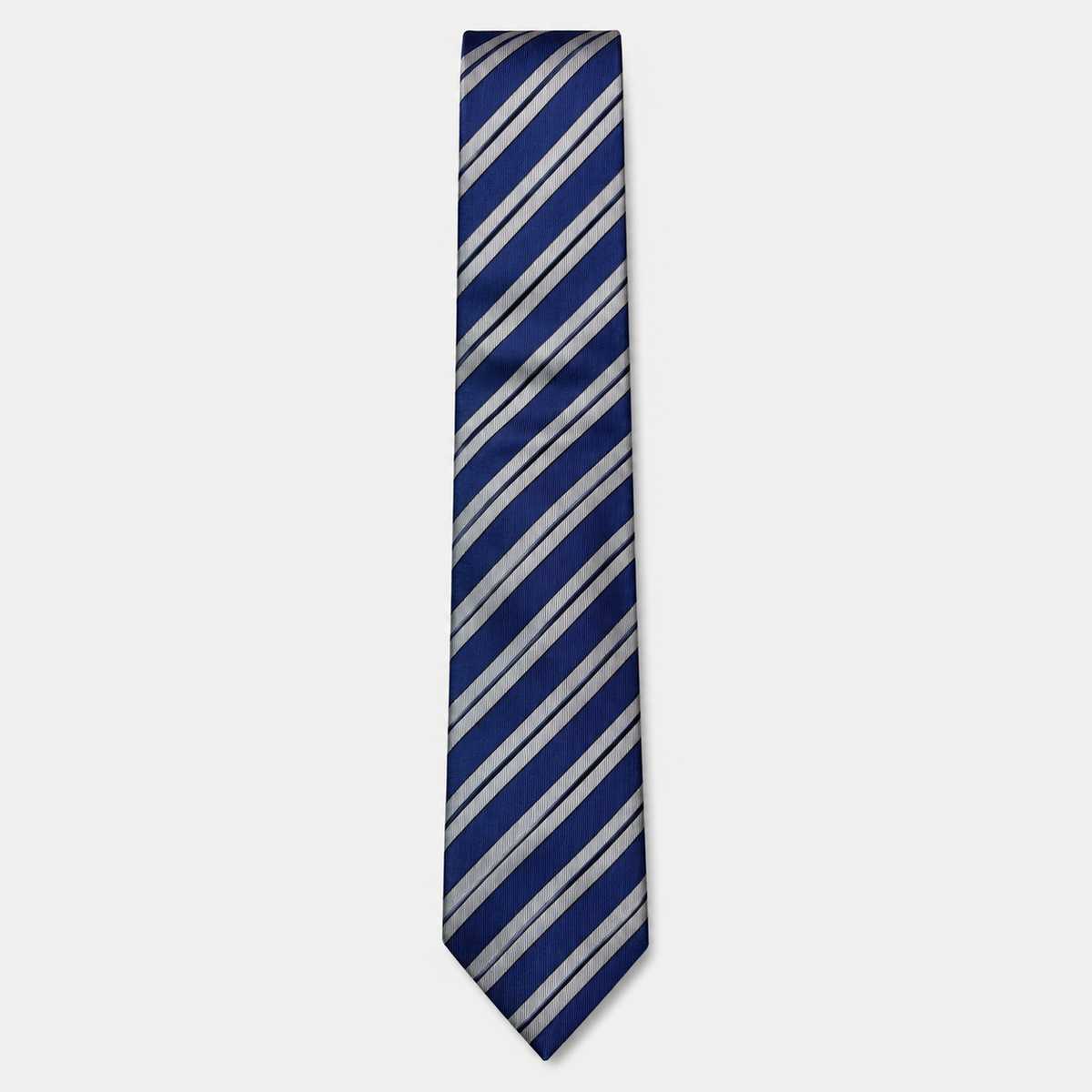 The Ancona Tie – navy, light blue and silver diagonal stripe silk tie on a light grey background