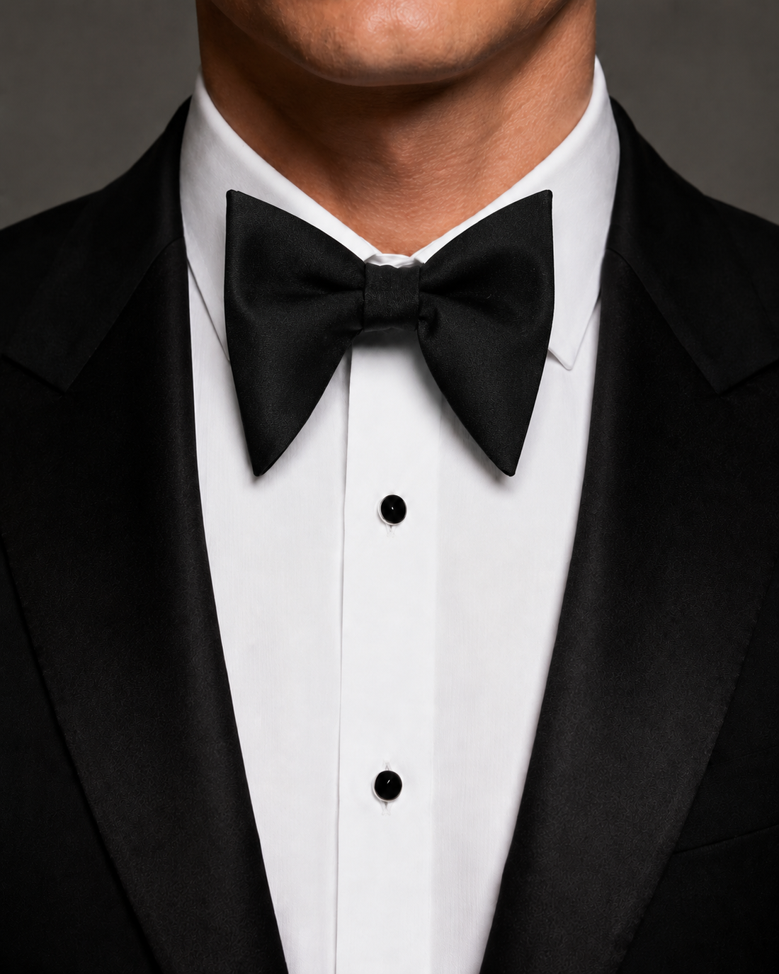 Black butterfly silk bow tie worn with a black tuxedo and white dress shirt.