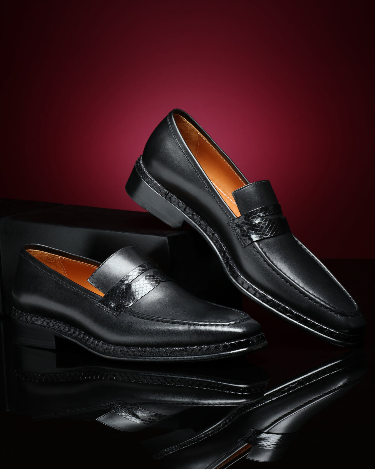URBBANA black python-skin penny loafers.