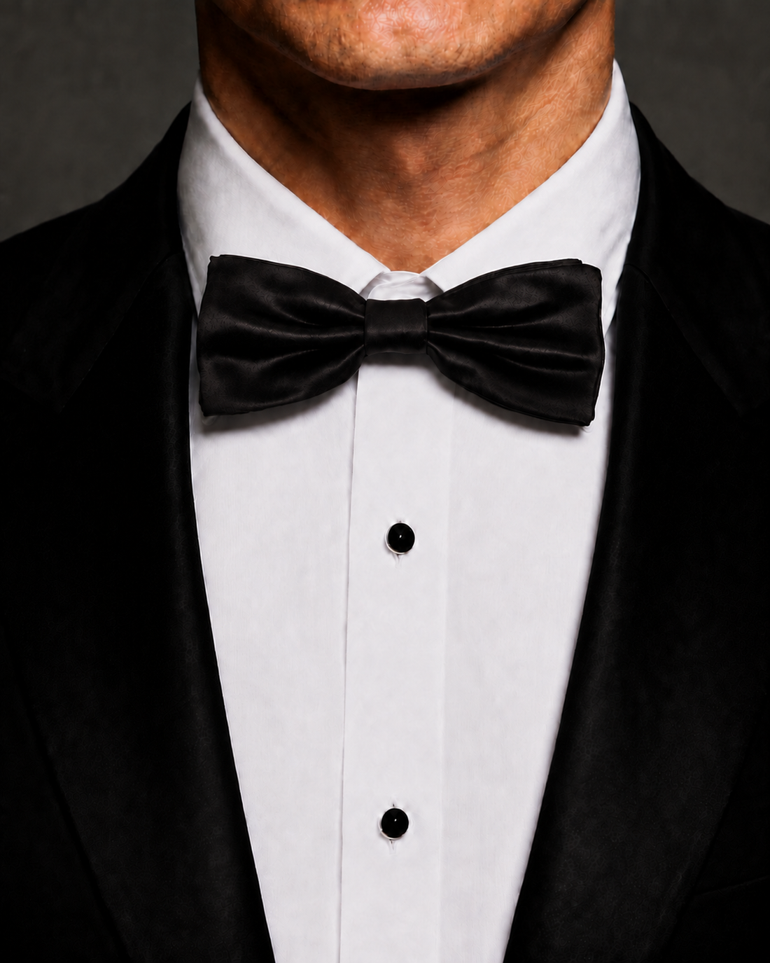 Black silk velvet bow tie worn with a black tuxedo and white dress shirt.