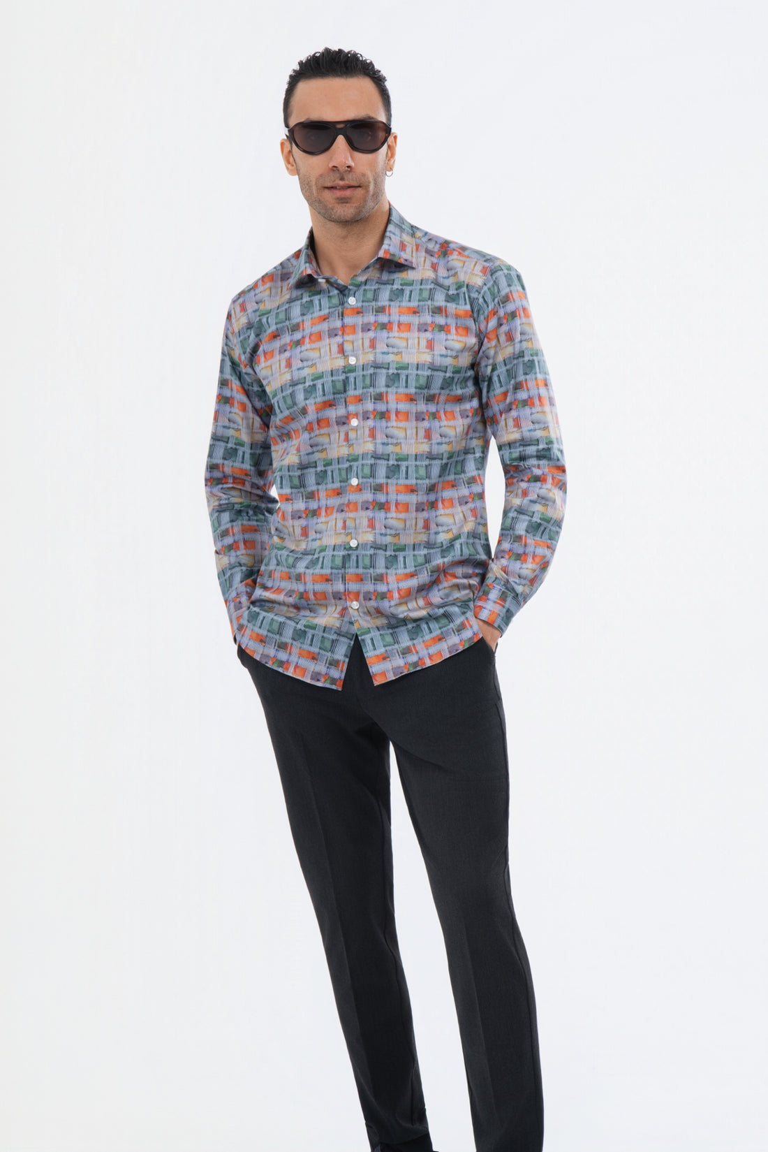 Male model wearing a multicolour geometric striped shirt with black trousers.