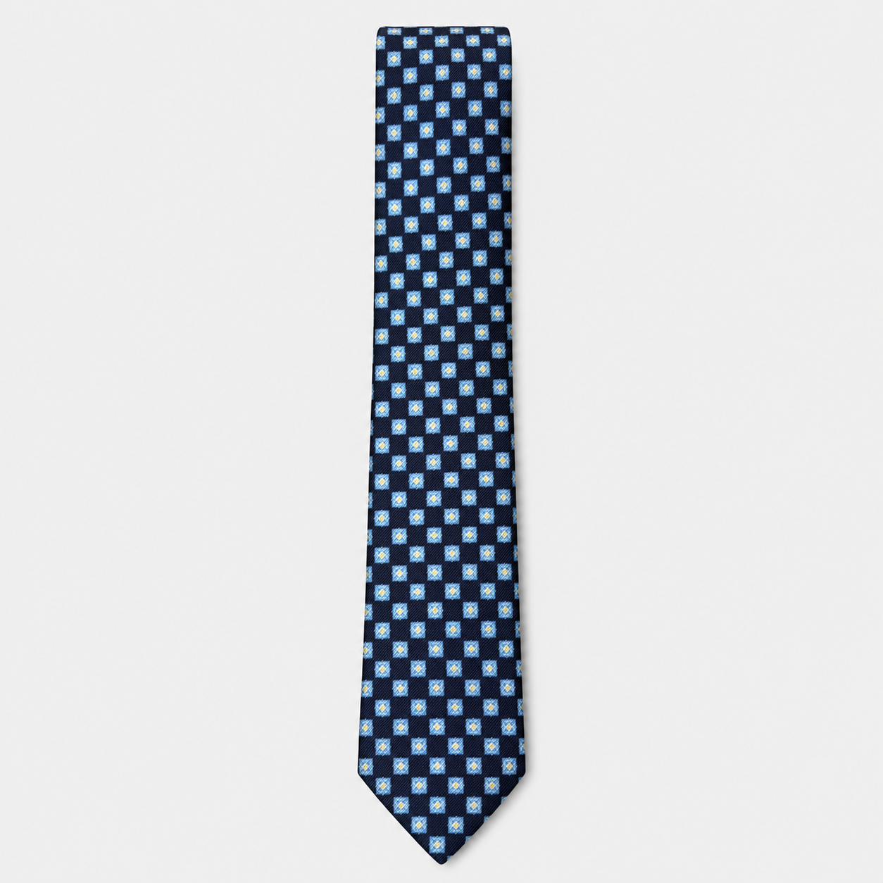 The Novara Tie – navy and white checkerboard silk tie on a light grey background