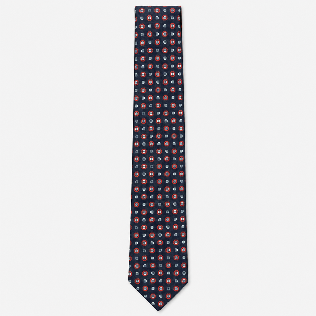 The Spoleto Tie – navy, red and pale blue dot medallion silk tie on a light grey background