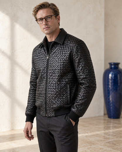 Male model wearing the Black Braided Leather jacket beside a blue glazed ceramic vase