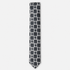 The Avellino Tie – black and ivory square medallion silk tie on a light grey background