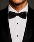 Black silk velvet bow tie worn with a black tuxedo and white dress shirt.