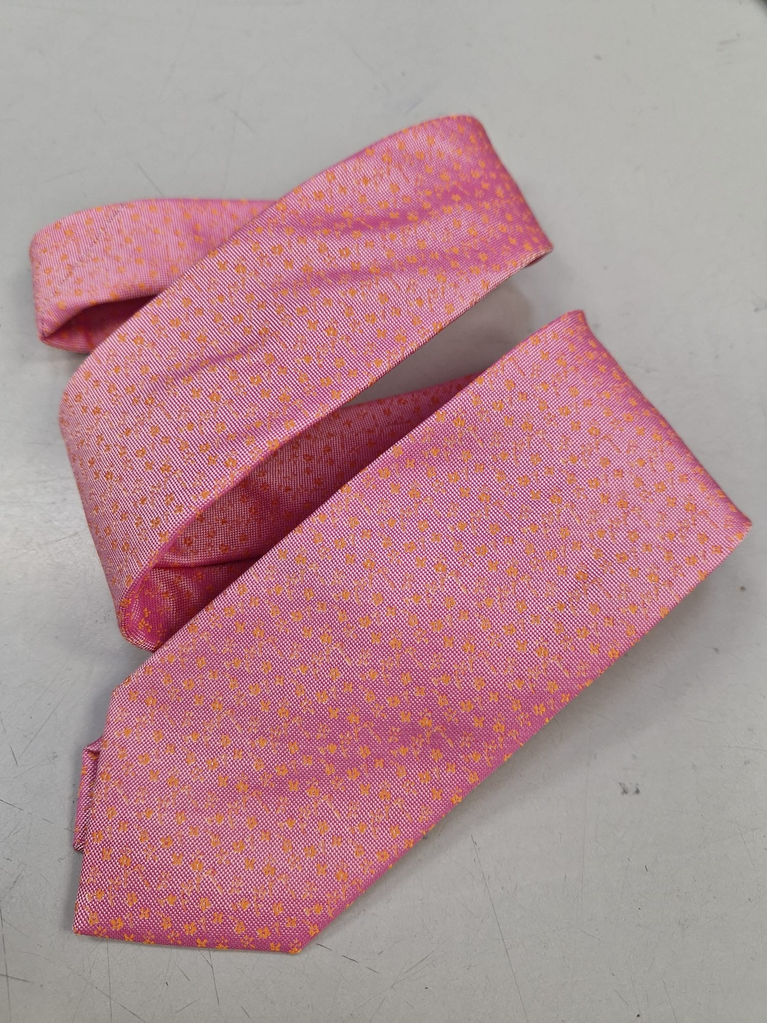 Bright pink textured silk tie, loosely folded.