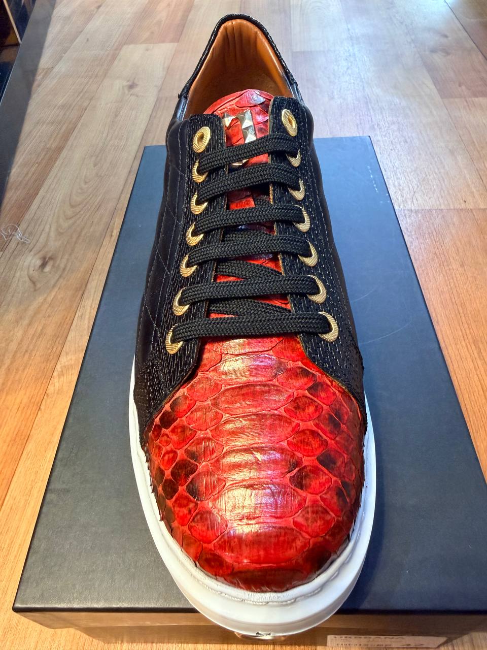 Brown and red exotic leather low-top sneaker with a white sole.