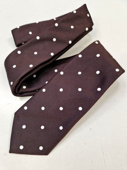 Brown silk tie with white polka dots, loosely folded.