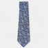 The Genova Tie, an ivory silk tie with a dense navy and blue floral print on a light grey background.