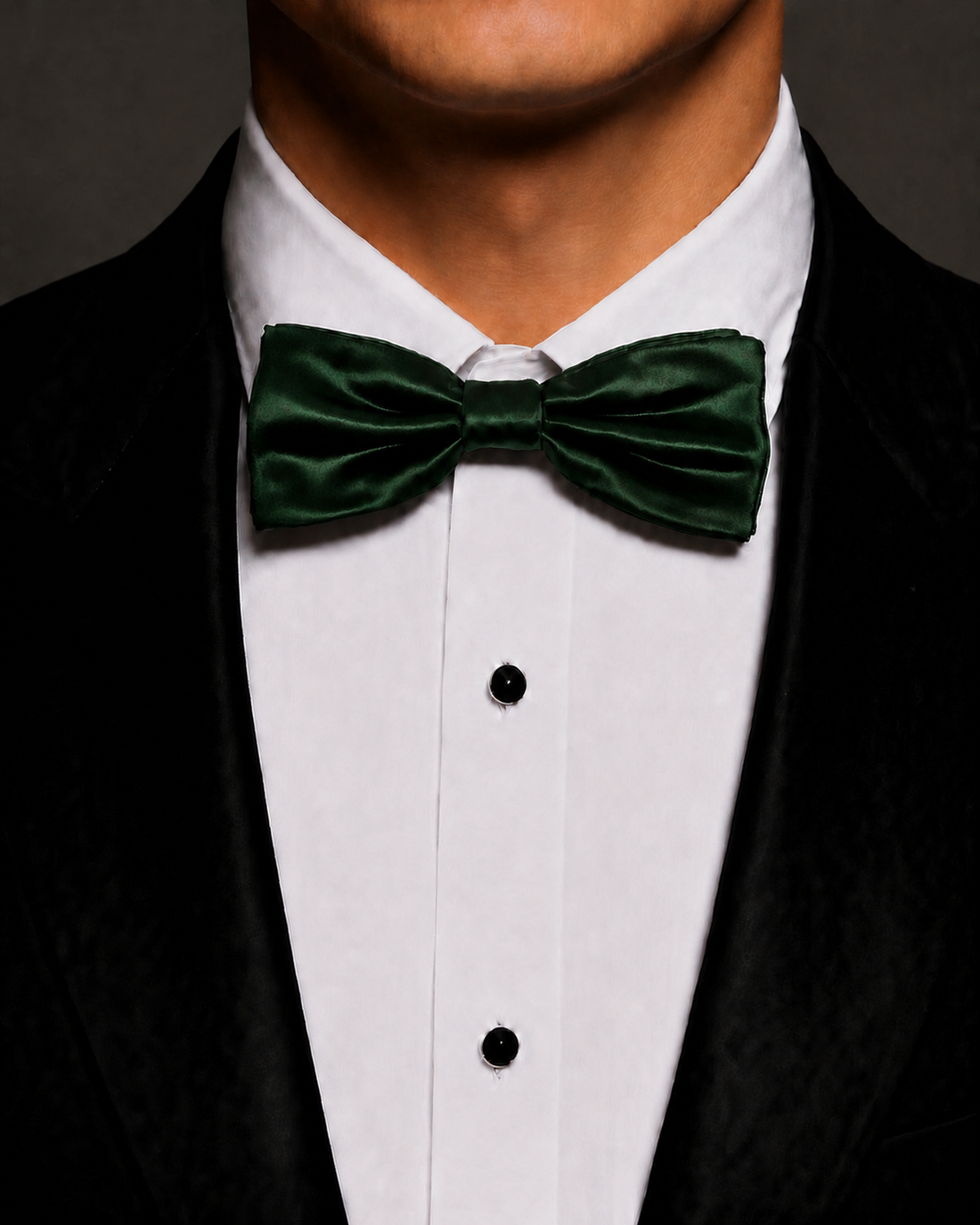 Green silk velvet bow tie worn with a black tuxedo and white dress shirt.