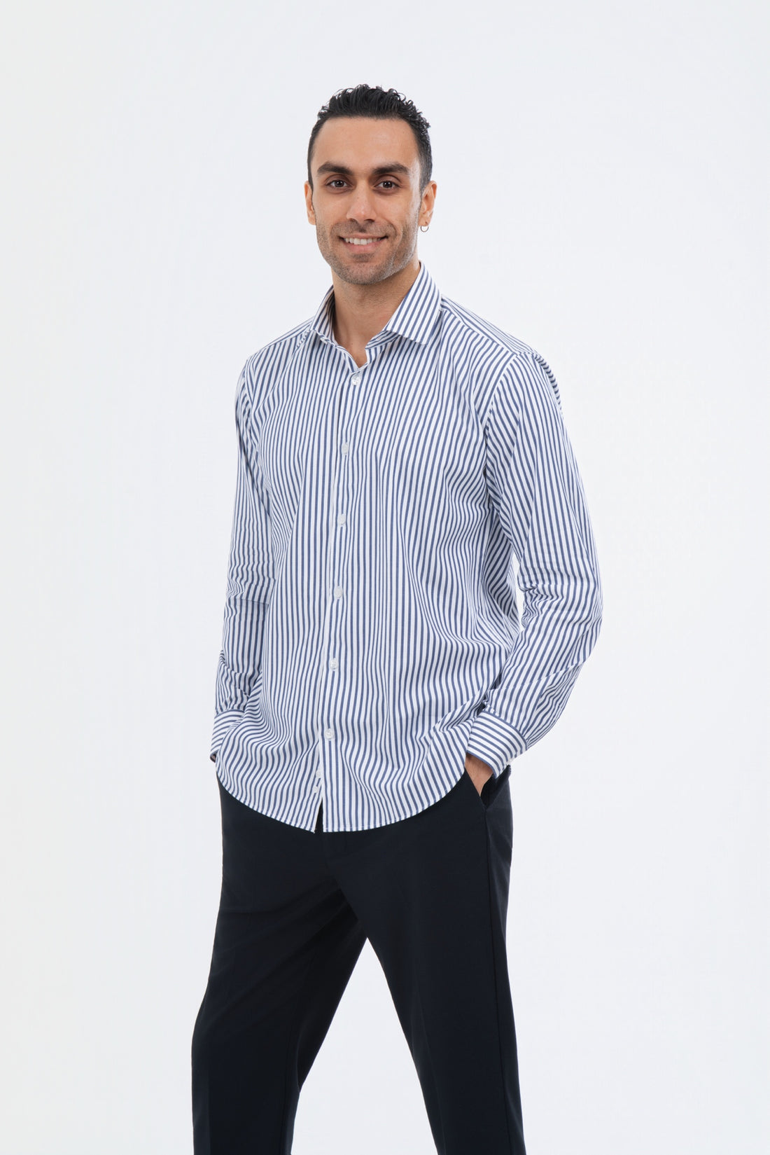 Male model wearing a light blue striped shirt with black trousers in the studio.