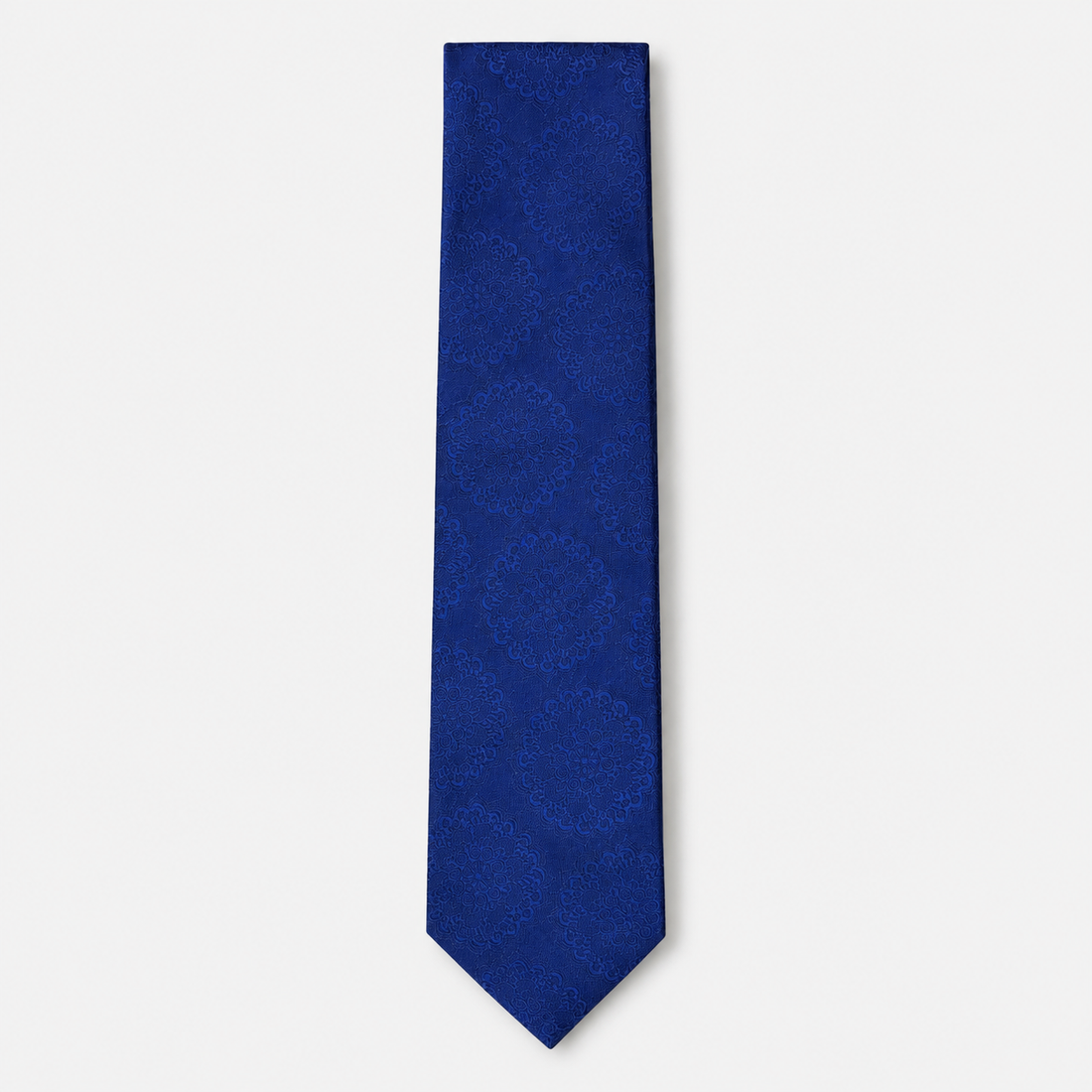 The Livorno Tie, a royal blue silk tie with a tonal floral medallion jacquard on a light grey background.