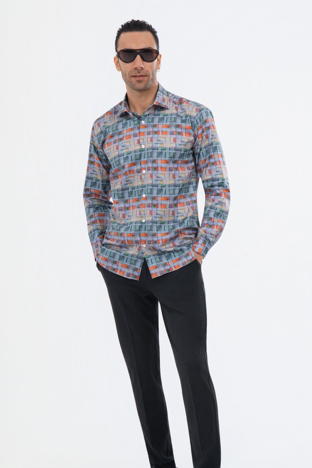 Male model wearing a multicolour geometric striped shirt with black trousers.