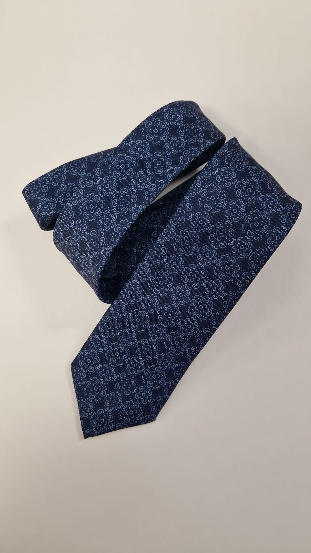 Navy tonal floral silk tie, loosely folded.