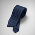 Navy tonal floral silk necktie on a grey background.