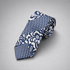 Navy and white geometric floral silk necktie on a grey background.