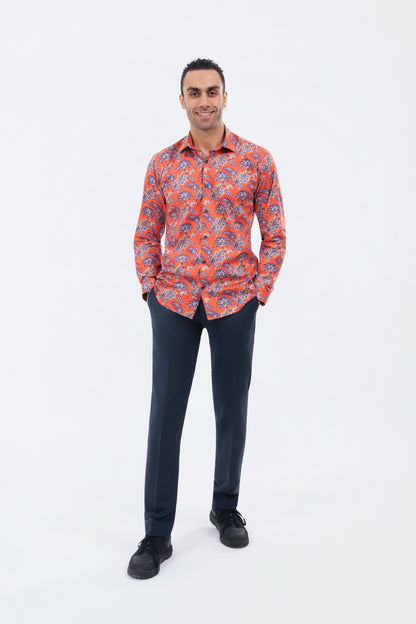 Male model wearing a bright orange paisley shirt with navy trousers.