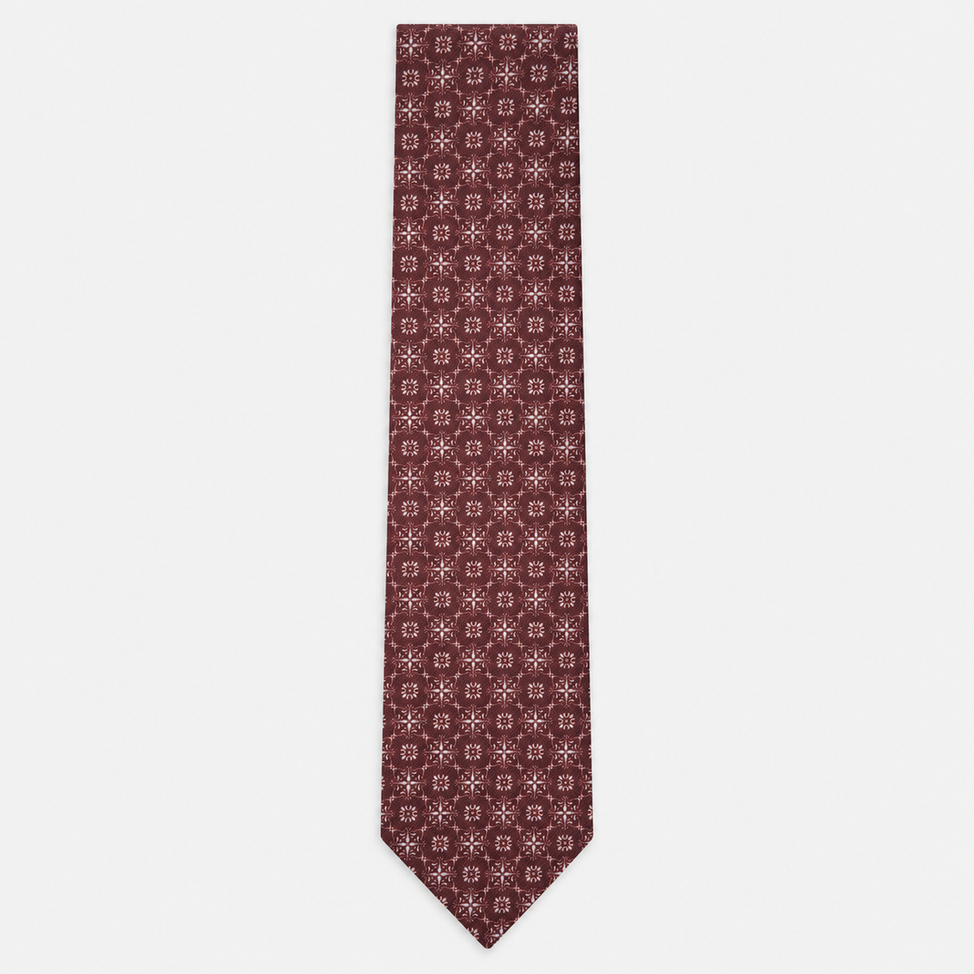 The Pavia Tie – burgundy and ivory micro rosette silk tie on a light grey background