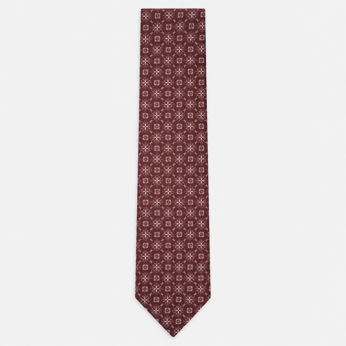 The Pavia Tie – burgundy and ivory micro rosette silk tie on a light grey background