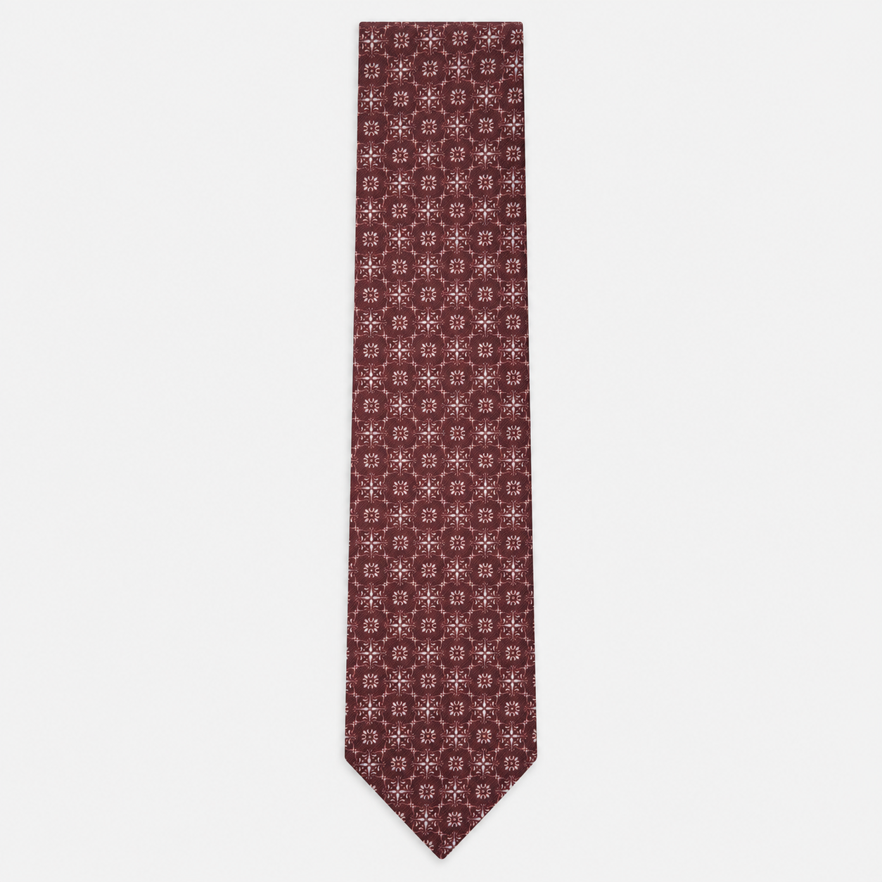 The Pavia Tie – burgundy and ivory micro rosette silk tie on a light grey background