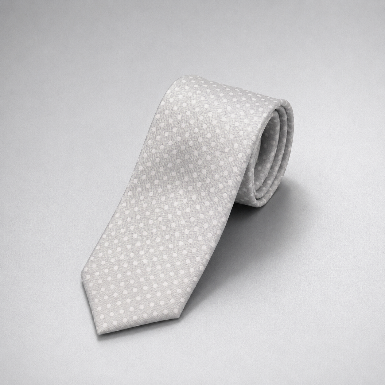 Silver silk necktie with a subtle white dot pattern on a grey background.
