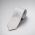 Silver silk necktie with a subtle white dot pattern on a grey background.