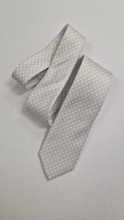 Silver silk tie with a subtle white dot pattern, loosely folded.