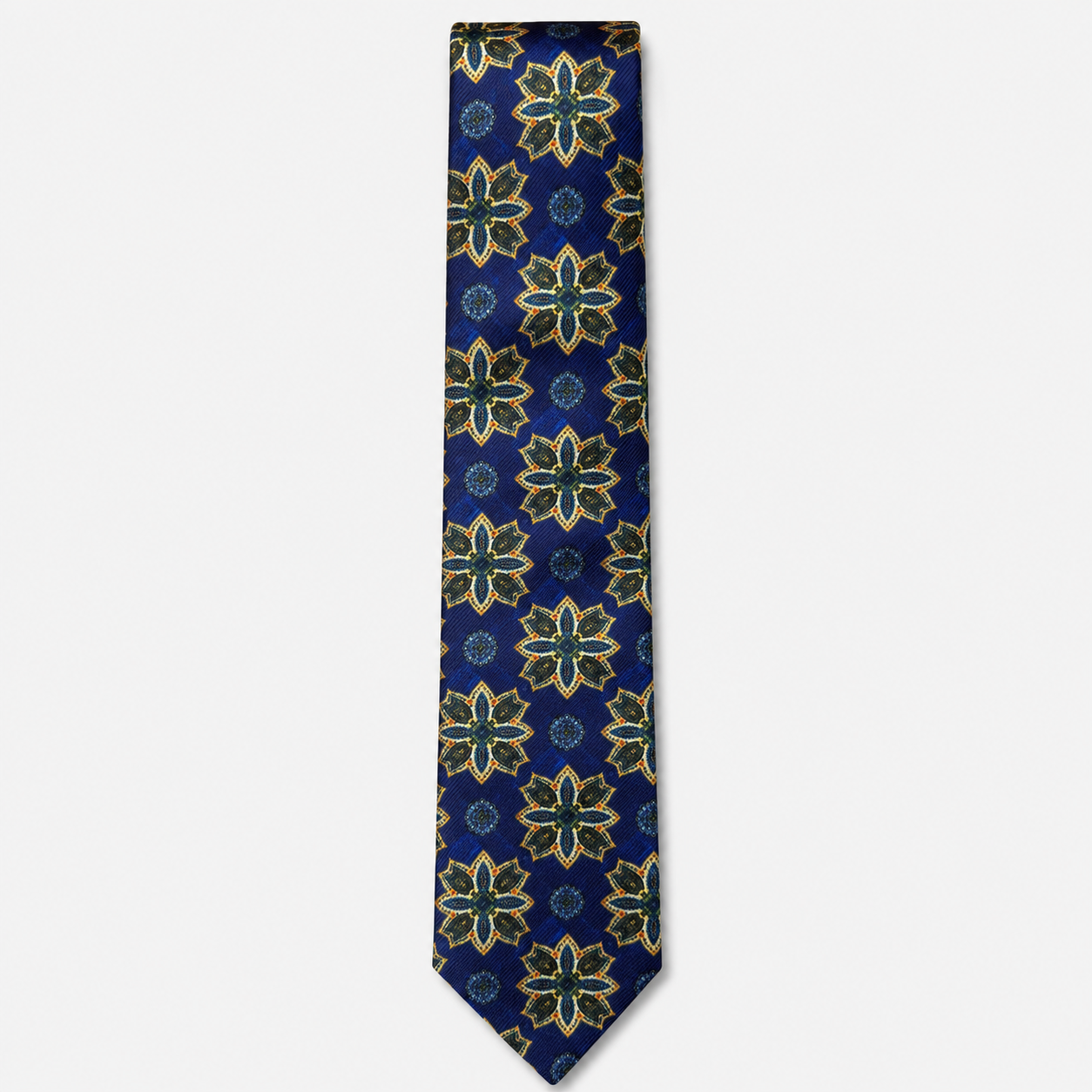 The Siracusa Tie – royal blue, gold and teal floral medallion silk tie on a light grey background