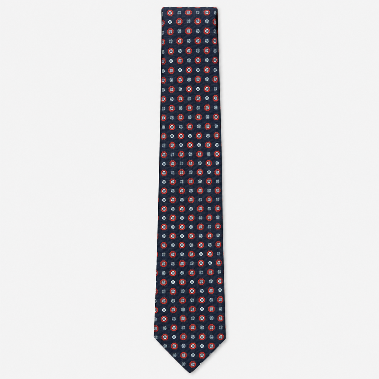 The Spoleto Tie – navy, red and pale blue dot medallion silk tie on a light grey background