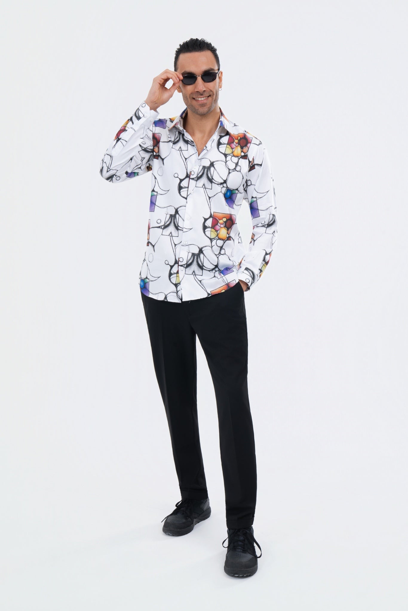 Male model wearing a white illustrated-print shirt with black trousers.